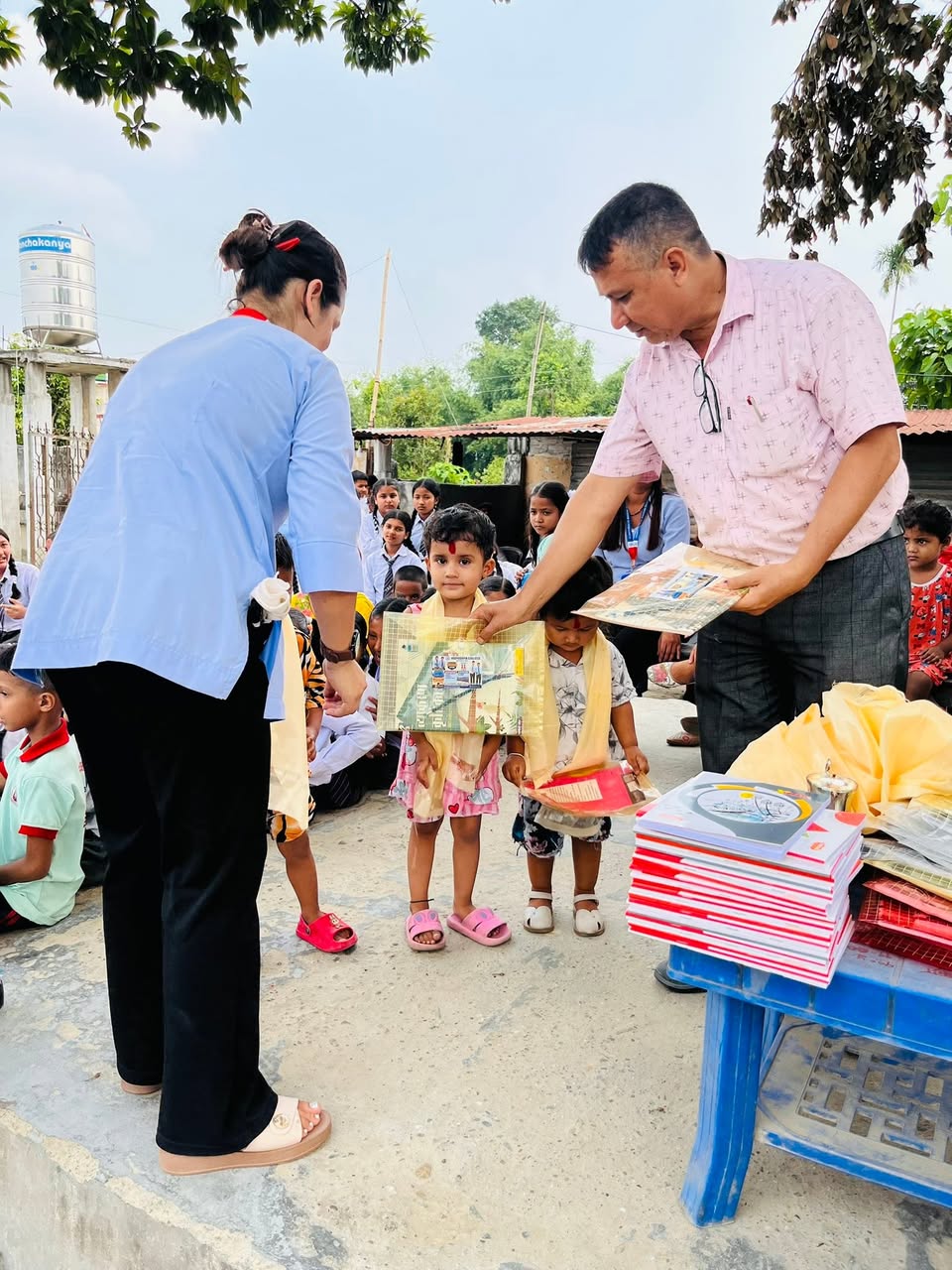 Principal and faculty welcoming young primary students with blessing tika and new books